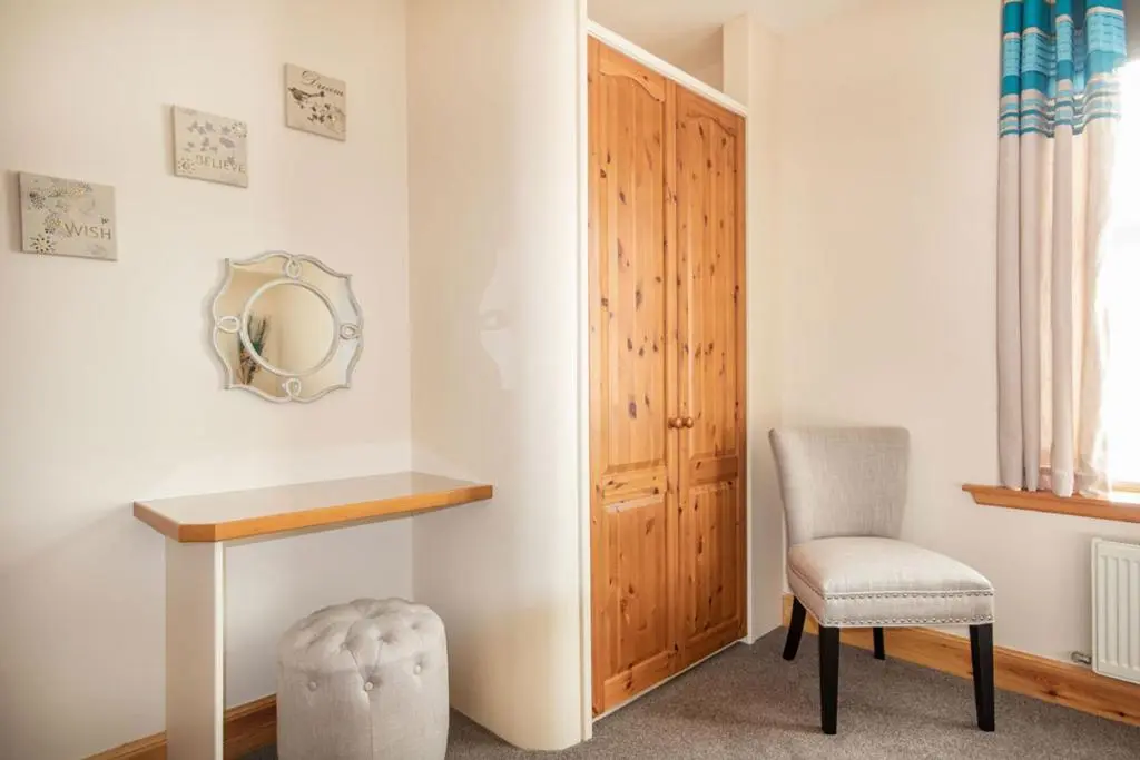a room with a table and a chair and a mirror at Innes Street Apartments in Inverness