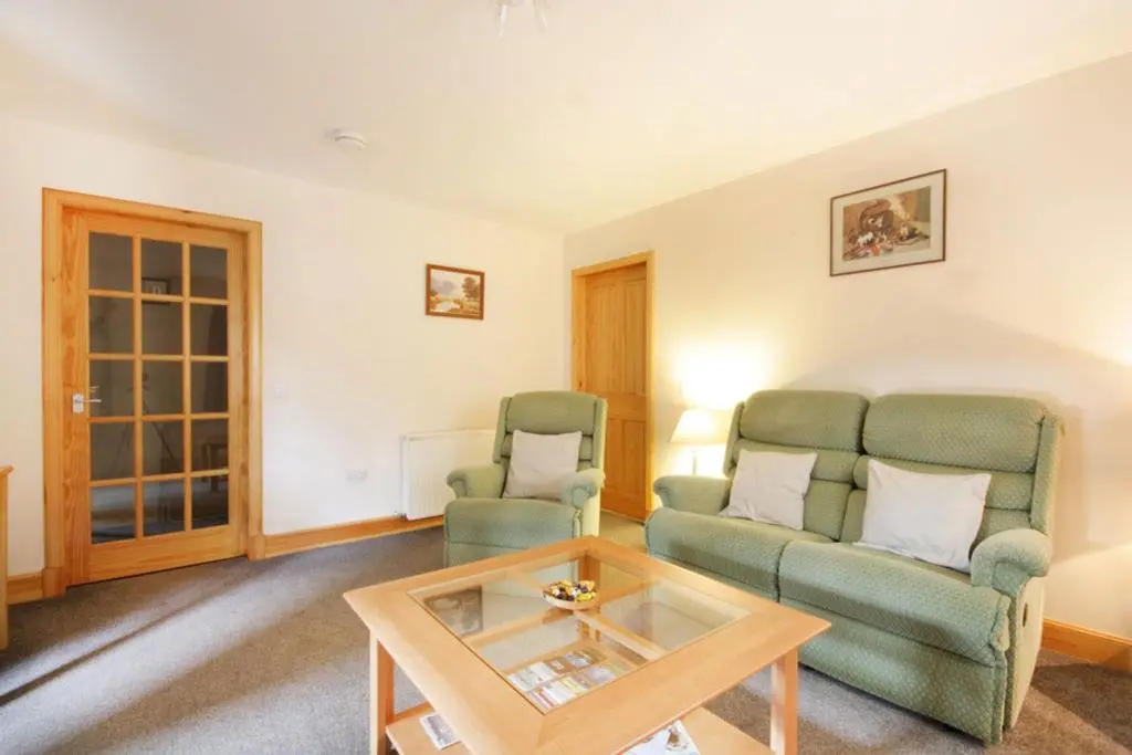 a living room with two chairs and a coffee table at Innes Street Apartments in Inverness
