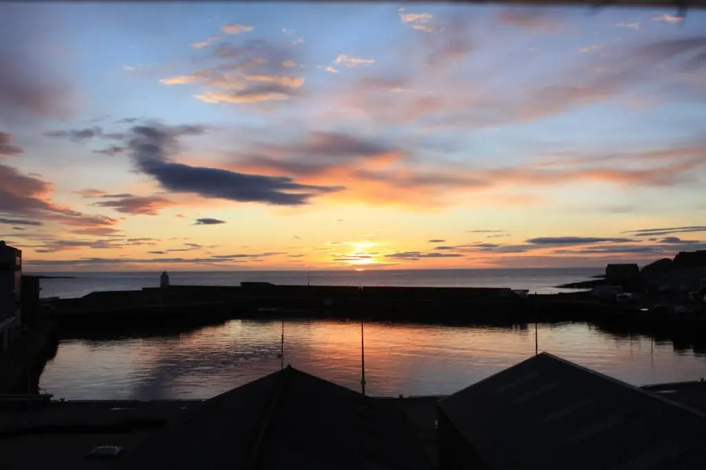 a sunset over a body of water with the sky at Harbour House Bed & Breakfast - Wick in Wick