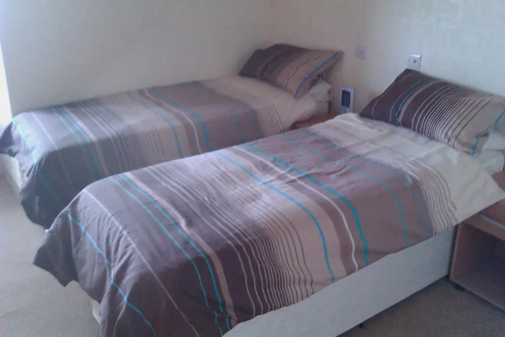 a bedroom with two beds with striped sheets at Harbour House Bed & Breakfast - Wick in Wick