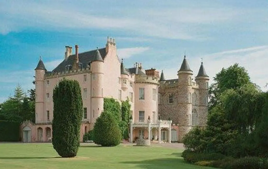 a large castle sitting on top of a lush green field at Balnagown Estates in Kildary
