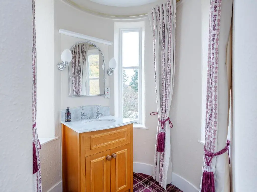 a bathroom with a sink and a mirror at Craigendarroch House in Ballater