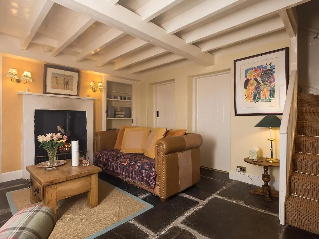 a living room with a couch and a fireplace at Big Barns Cottage in Backies