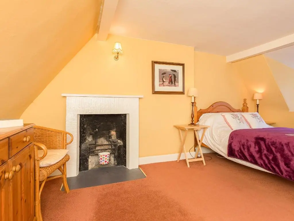 a bedroom with a bed and a fireplace at Big Barns Cottage in Backies