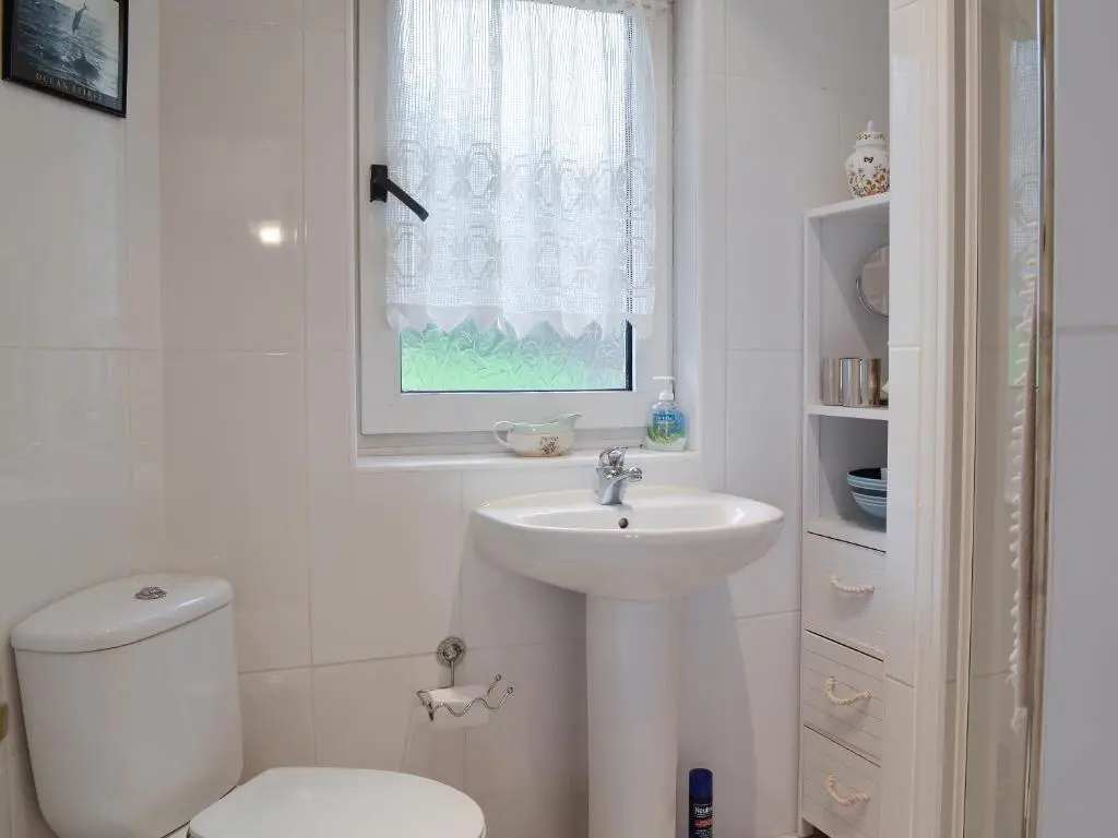 a white bathroom with a toilet and a sink at Ruach in Gardenstown