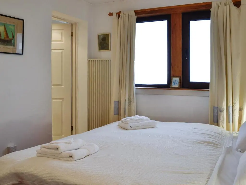 a bedroom with two towels on a white bed at Ruach in Gardenstown