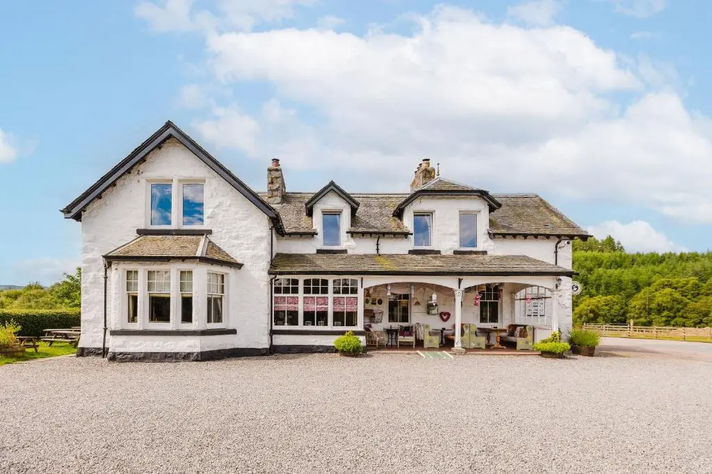 a large white house with a large driveway at Whitebridge Hotel in Whitebridge