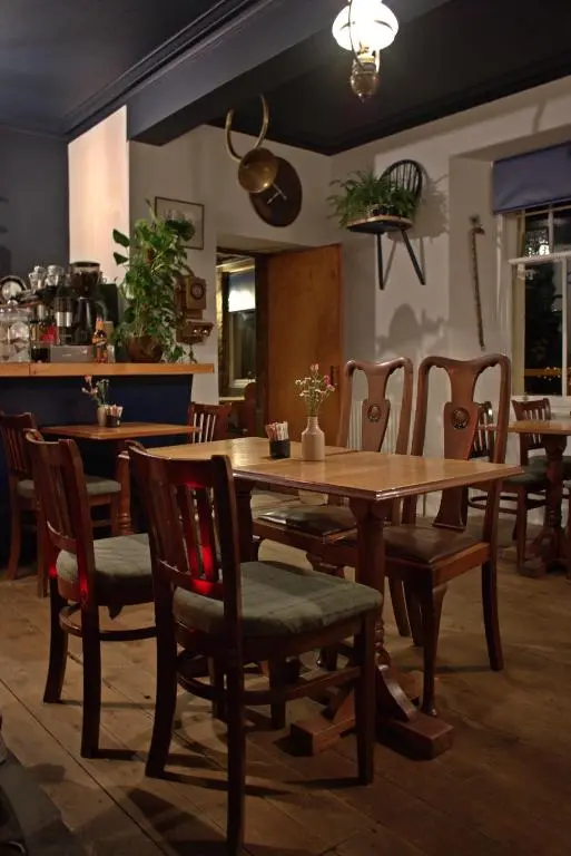 a dining room with a wooden table and chairs at Whitebridge Hotel in Whitebridge