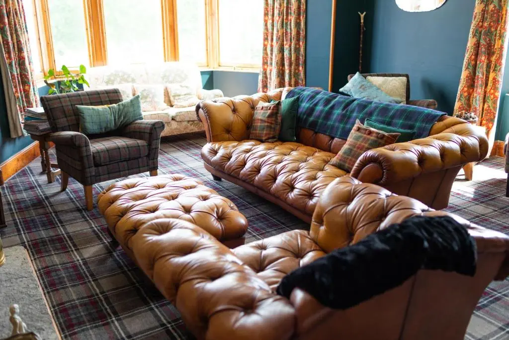 a living room with a brown leather couch at Whitebridge Hotel in Whitebridge