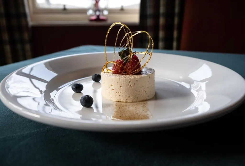 a white plate with a dessert on a table at Altnaharra Hotel in Lairg