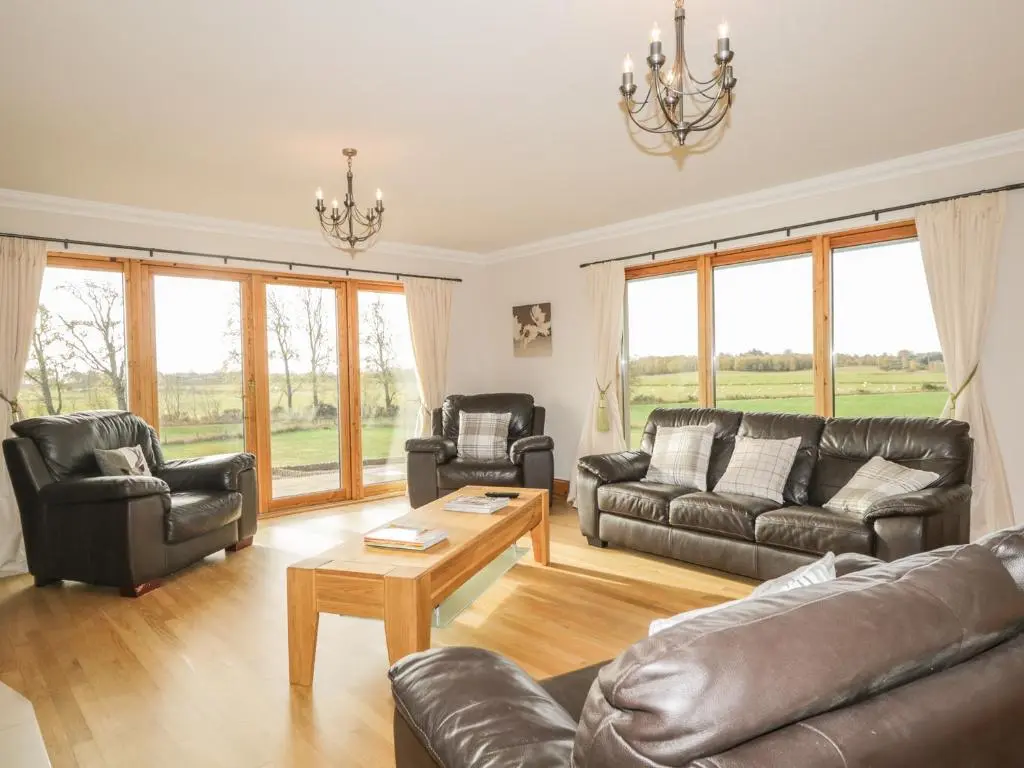 a living room with leather couches and a table at The Glebe in Invergordon