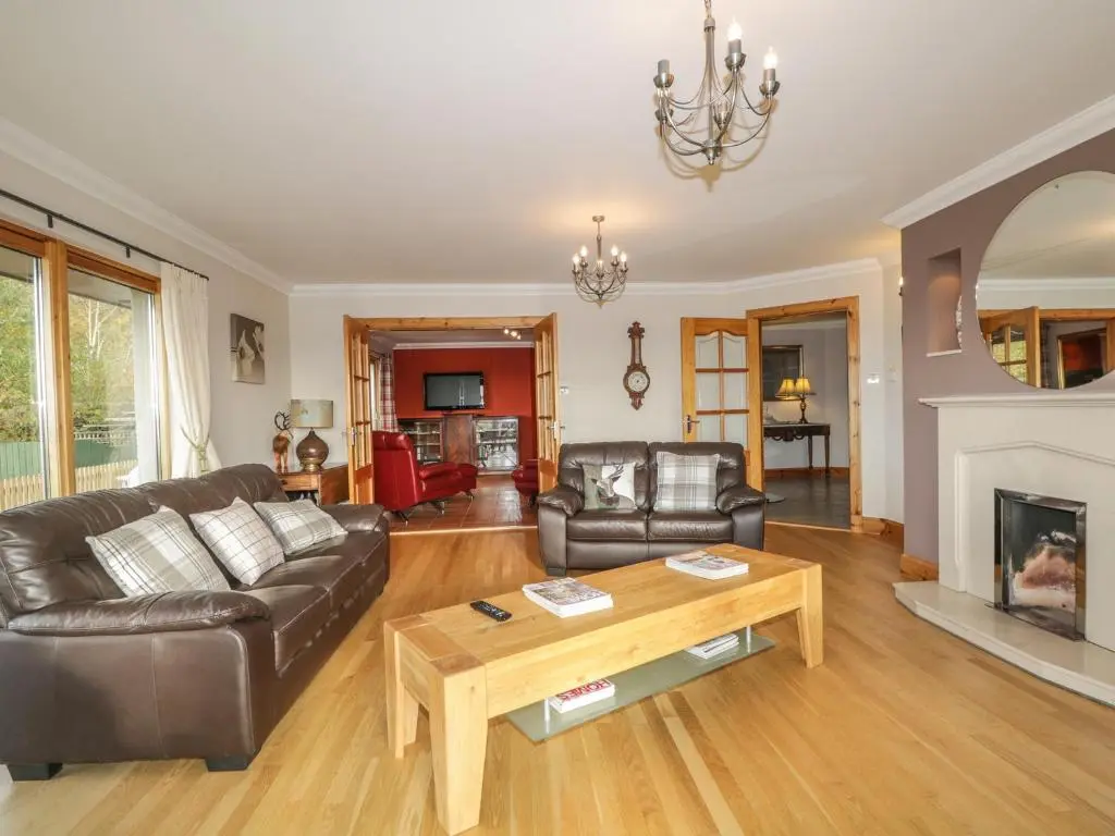 a living room with leather furniture and a fireplace at The Glebe in Invergordon