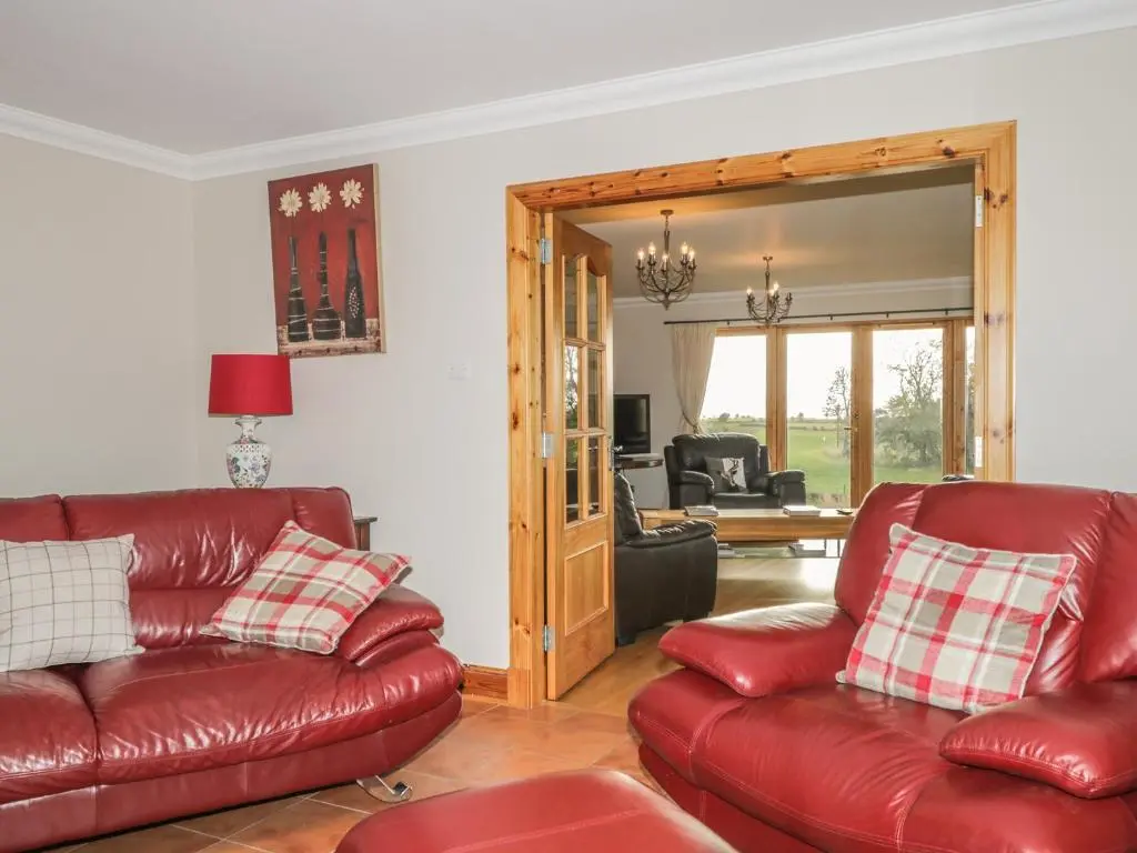 a living room with two red leather couches at The Glebe in Invergordon