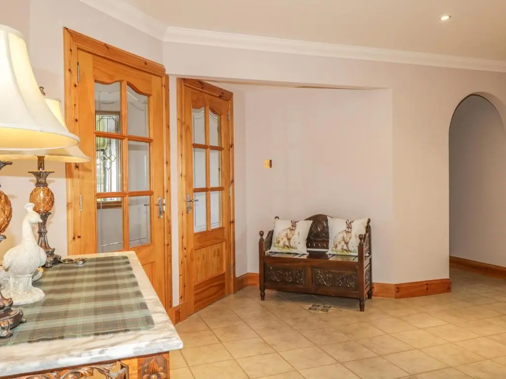 a living room with a table and a chair at The Glebe in Invergordon