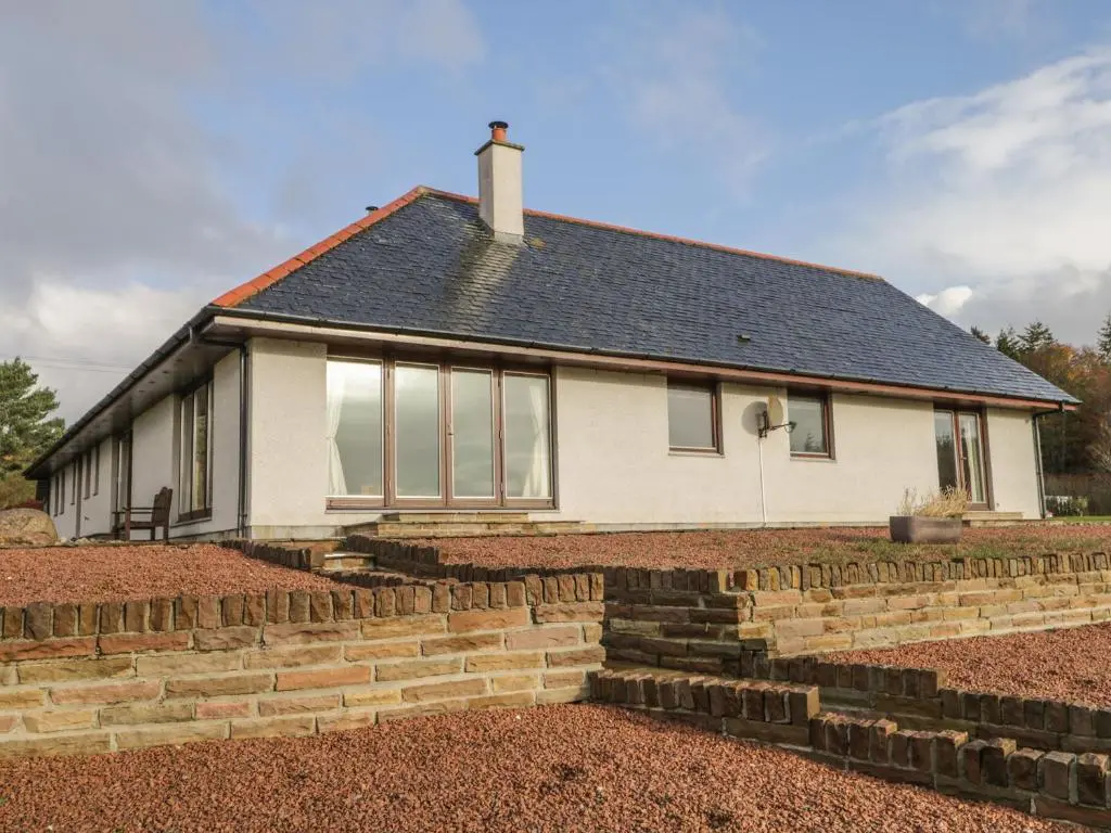 a house with a brick retaining wall in front of it at The Glebe in Invergordon