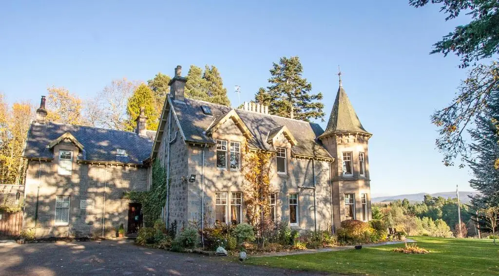 an old stone house with a yard at Tigh na Sgiath Country House Hotel in Grantown on Spey