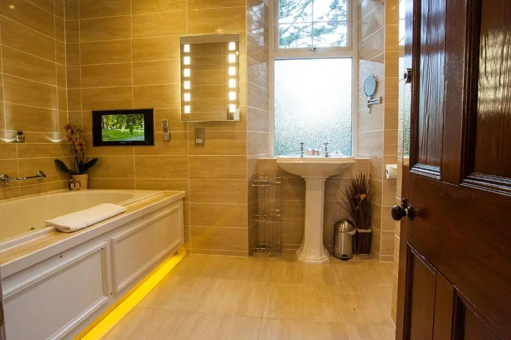 a bathroom with a tub and a sink and a window at Tigh na Sgiath Country House Hotel in Grantown on Spey