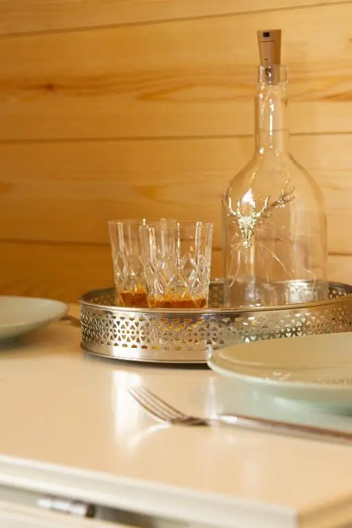 a table with glasses and a bottle on a tray at Evelix Pods Dornoch in Dornoch