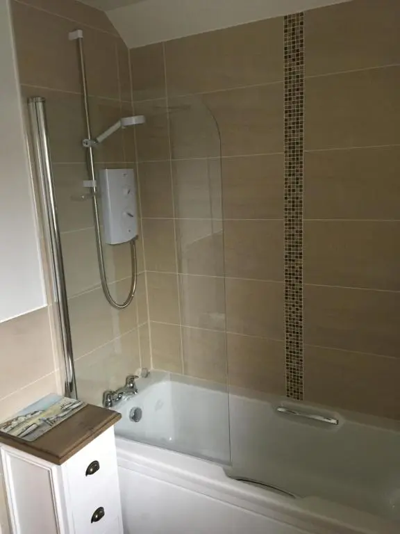 a bathroom with a shower and a bath tub with a sink at Riverbank Apartments in Nairn