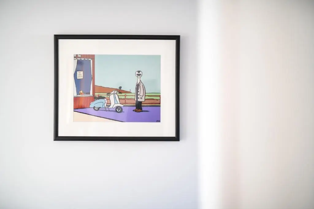 a framed picture of a man standing next to a car at Dryburgh Apartments No2 in Inverness