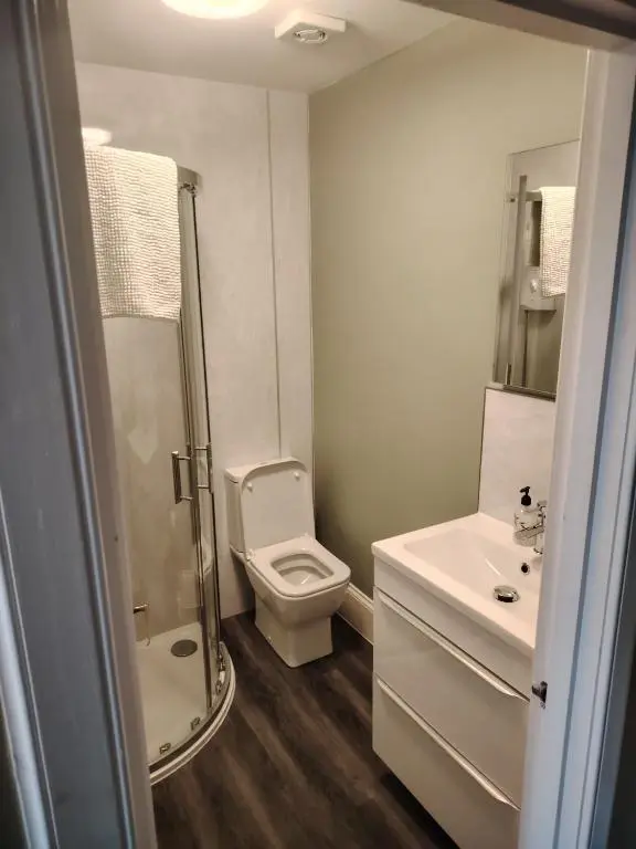 a white bathroom with a toilet and a sink at Park Guest House in Inverness