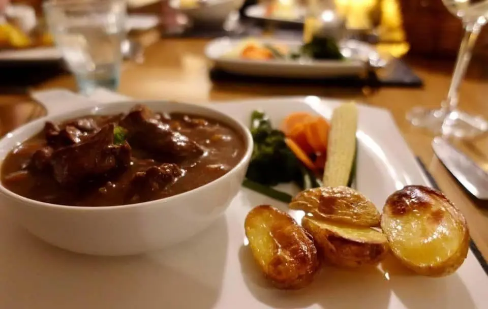 a white plate with a bowl of soup and some food at Binnilidh Mhor B&B in Glenmoriston