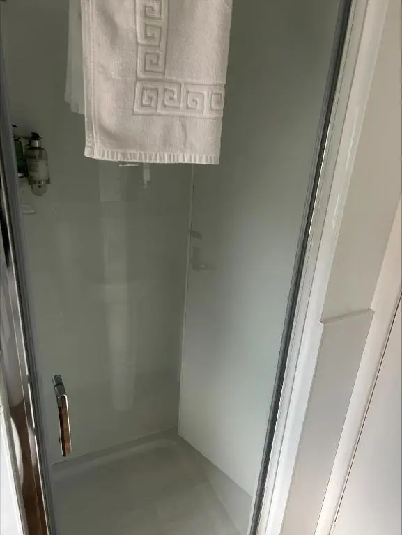 a shower with a glass door and a towel at Whisky Capital Inn in Dufftown