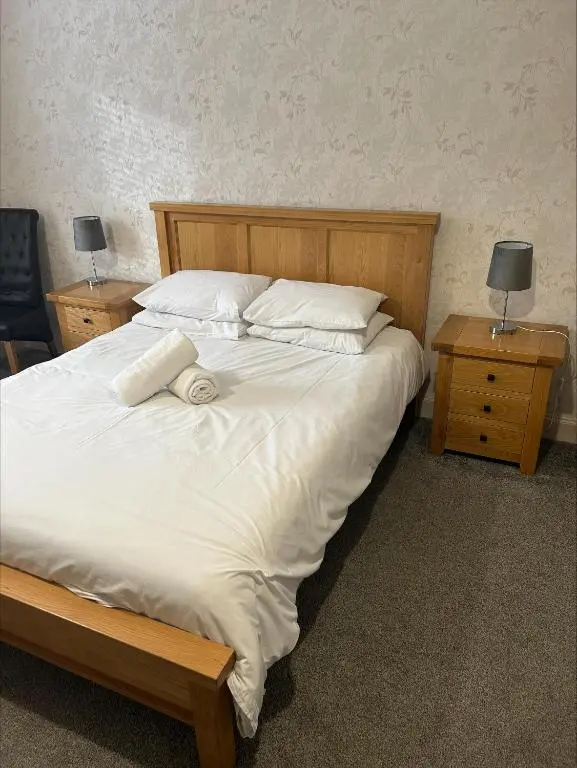 a bedroom with a large bed with white sheets and pillows at Whisky Capital Inn in Dufftown