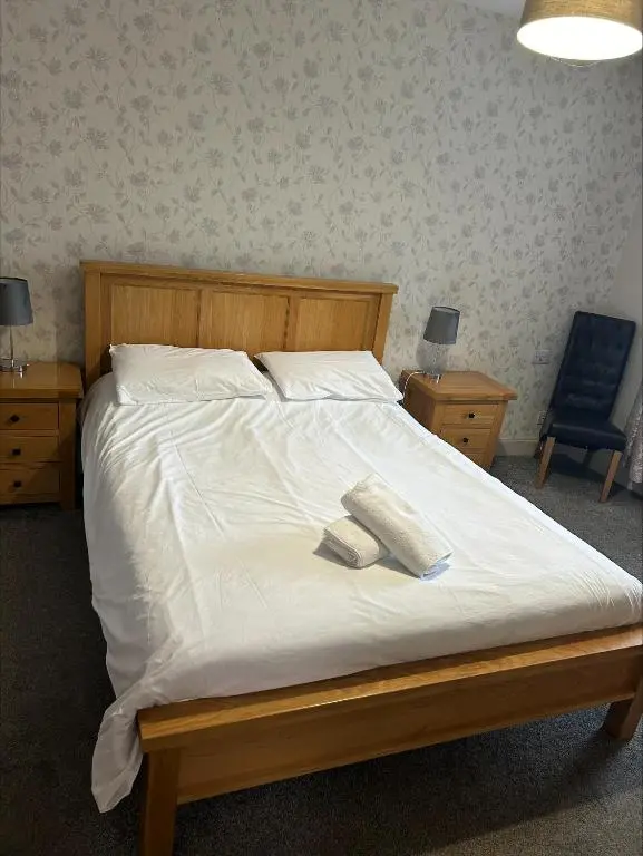 a bedroom with a bed with two towels on it at Whisky Capital Inn in Dufftown