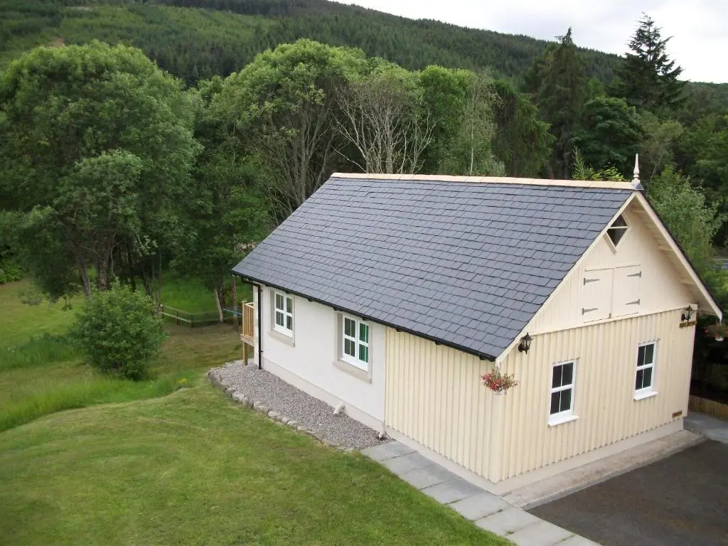 a small shed with a gray roof on a yard at River Cottage Hot tub spa in Drumnadrochit