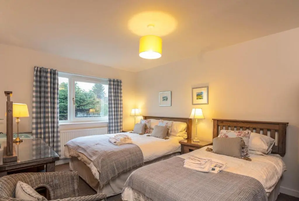 a bedroom with two beds and a window at Beachview-Holiday Flat 2- Sleeps8 in Lossiemouth