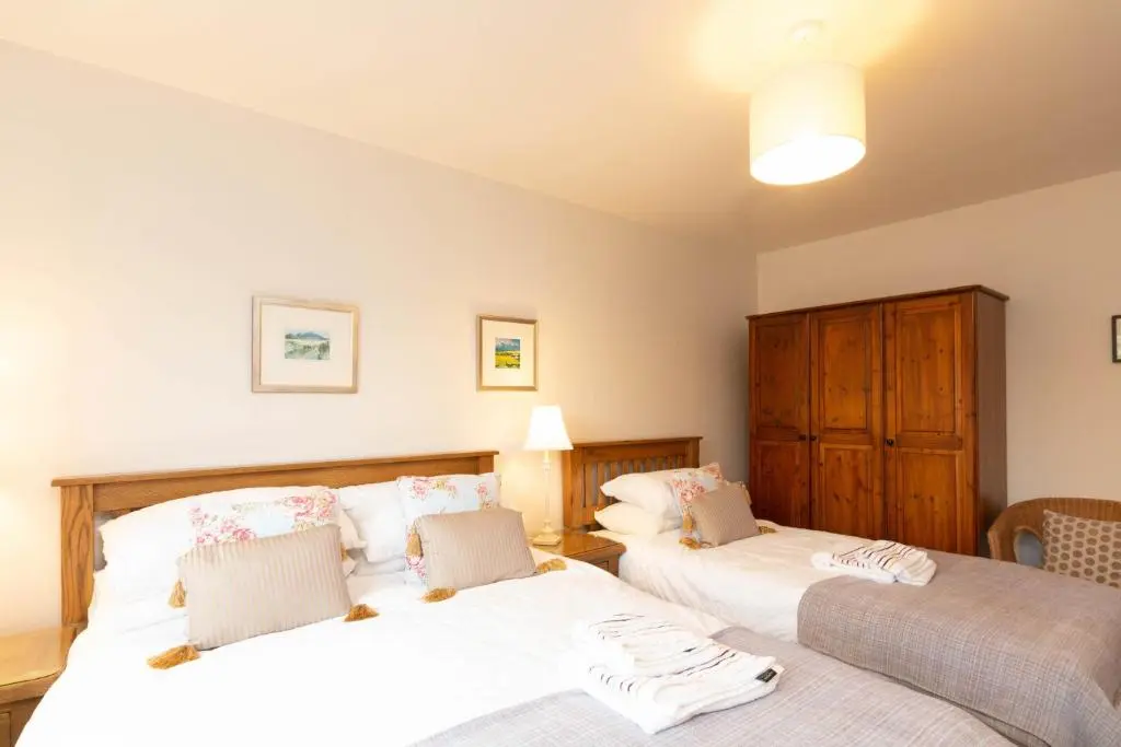 a bedroom with two beds with white sheets at Beachview-Holiday Flat 2- Sleeps8 in Lossiemouth