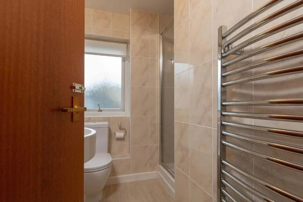 a bathroom with a toilet and a window at Beachview-Holiday Flat 2- Sleeps8 in Lossiemouth