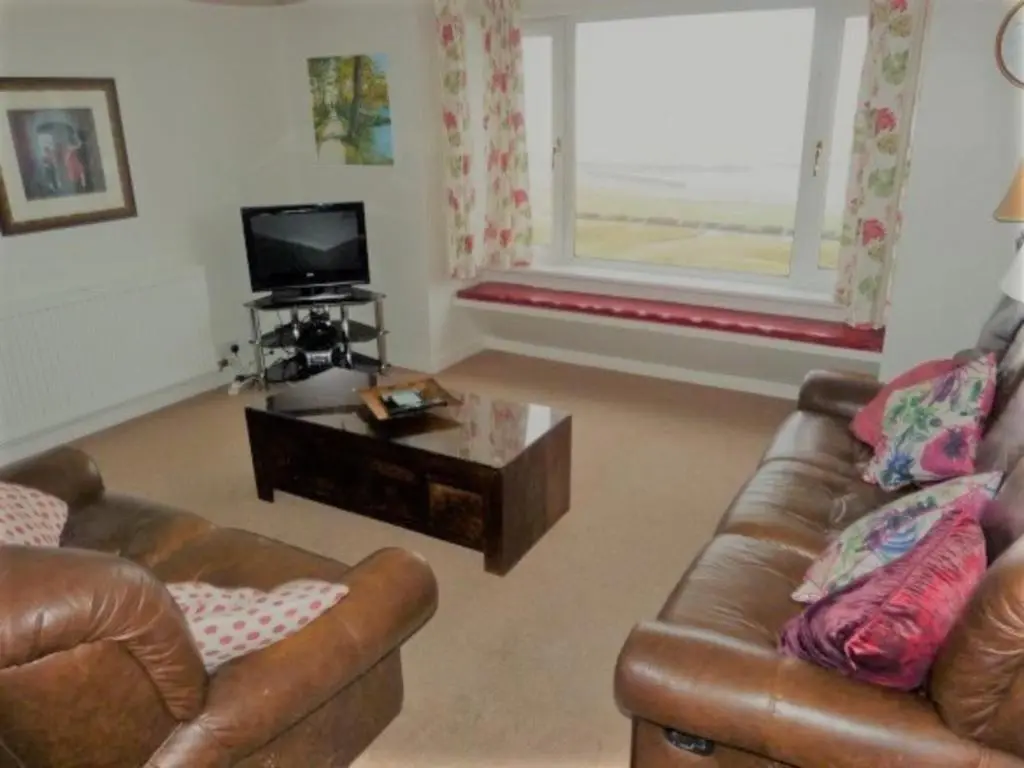 a living room with two leather couches and a coffee table at Beachview-Holiday Flat 2- Sleeps8 in Lossiemouth