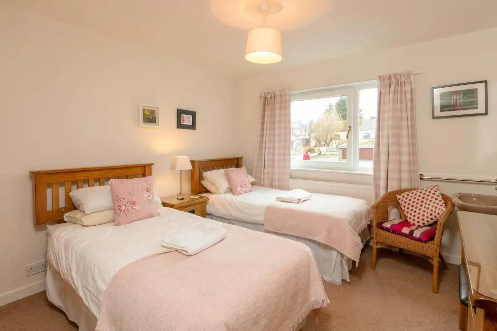 a bedroom with two beds and a window at Beachview-Holiday Flat 2- Sleeps8 in Lossiemouth