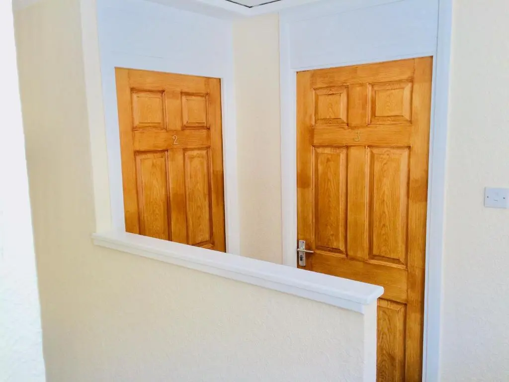 a bathroom with a mirror and a door at Invercaul House in Inverness