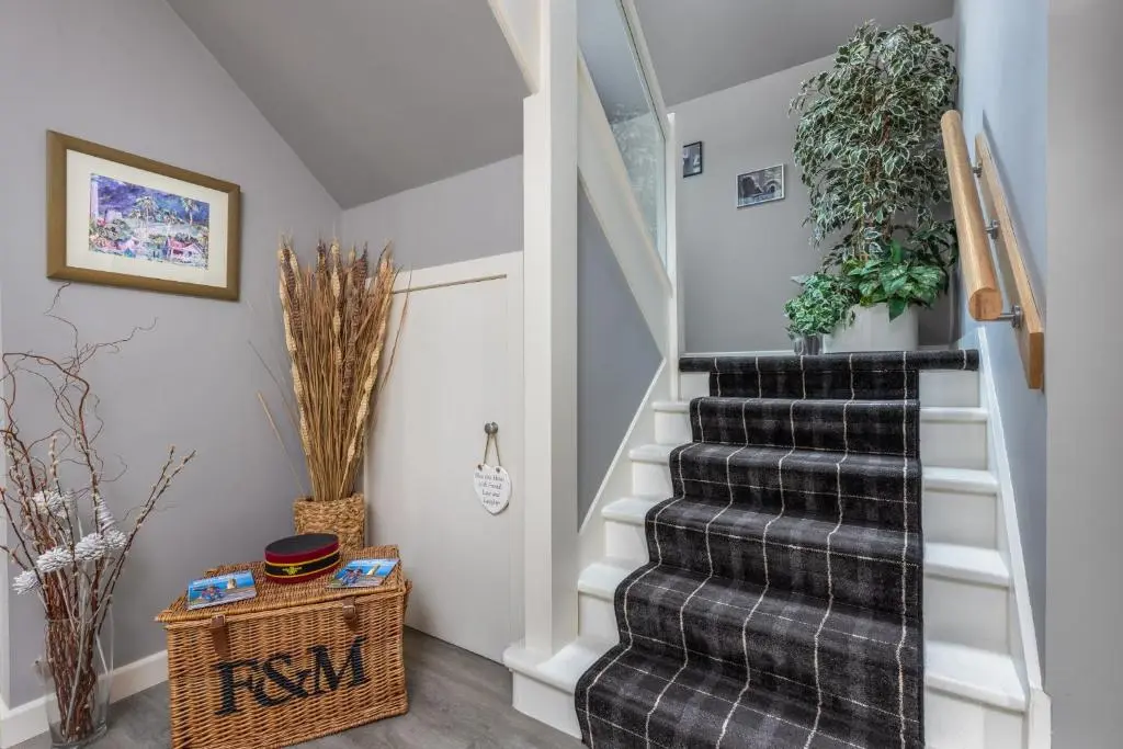 a stairway with a black and white rug at Heartseed House Bed & Breakfast in Dornoch