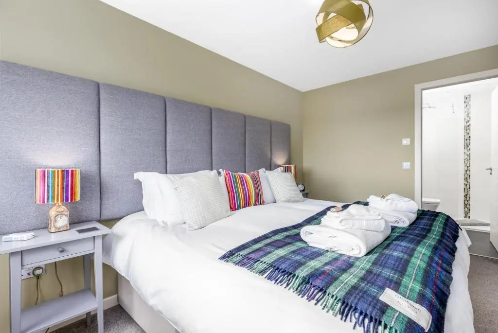 a bedroom with two beds with towels on a blanket at Heartseed House Bed & Breakfast in Dornoch