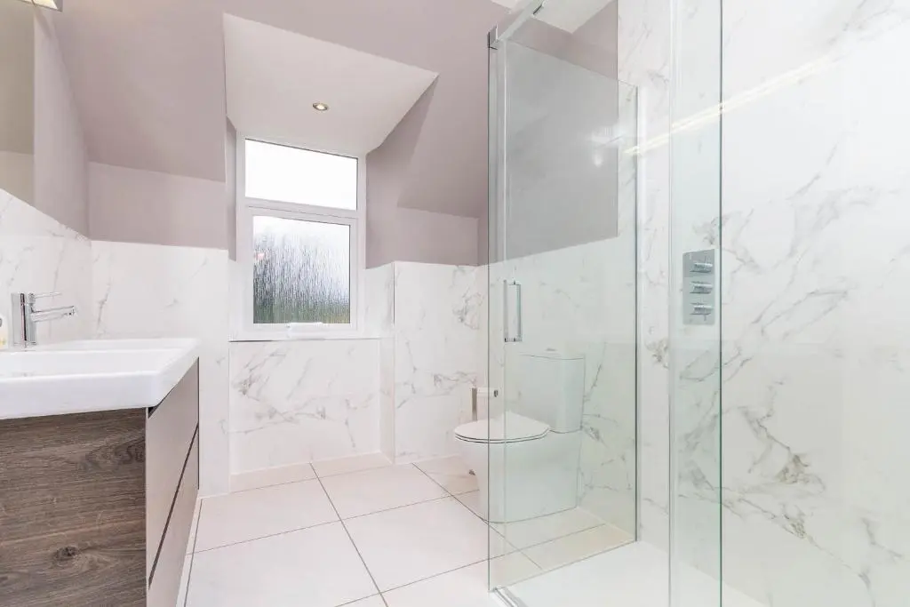 a white bathroom with a shower and a toilet at Convalmore House in Dufftown