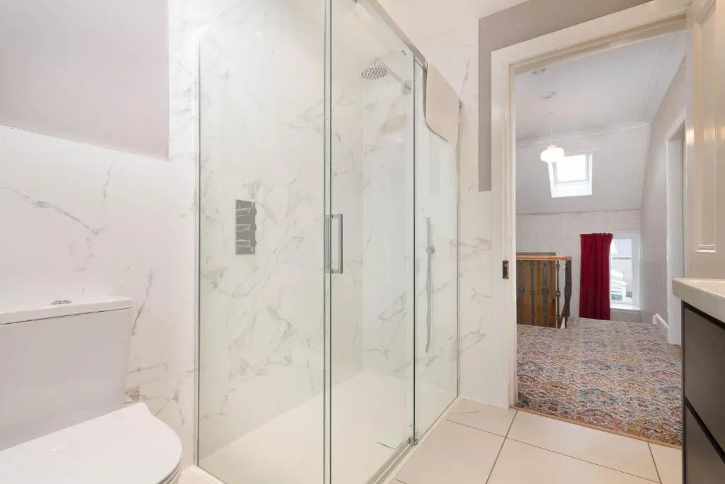 a bathroom with a glass shower with a toilet at Convalmore House in Dufftown