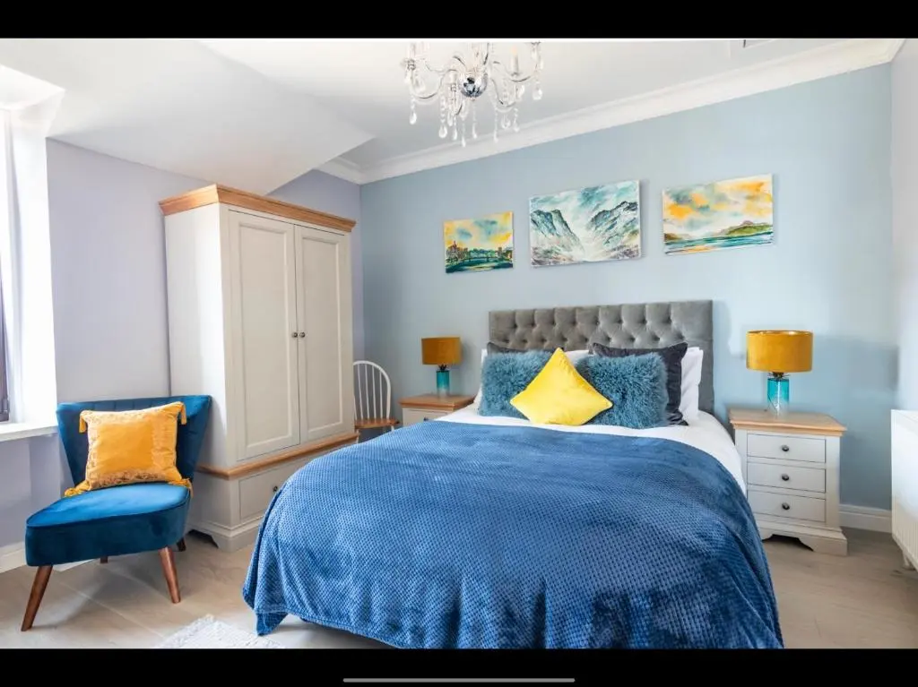 a blue bedroom with a bed and a chair at BlueNess in Inverness