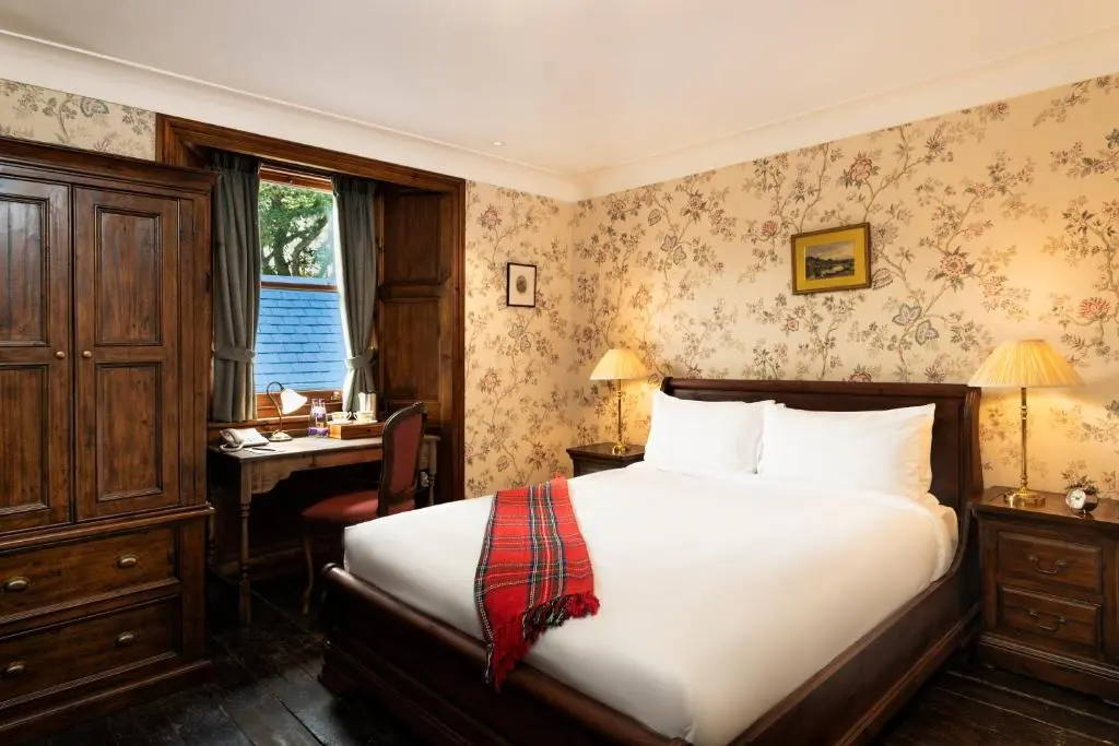 a bedroom with a bed and a desk with a computer at Rokeby Manor in Invergarry