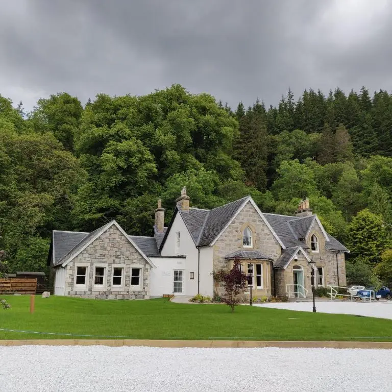 a large house with a green lawn in front at Rokeby Manor in Invergarry