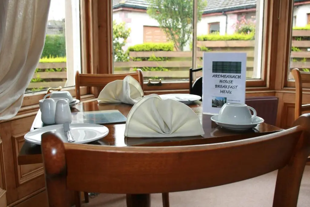 a wooden table with plates and bowls on it at Ardmeanach in Inverness