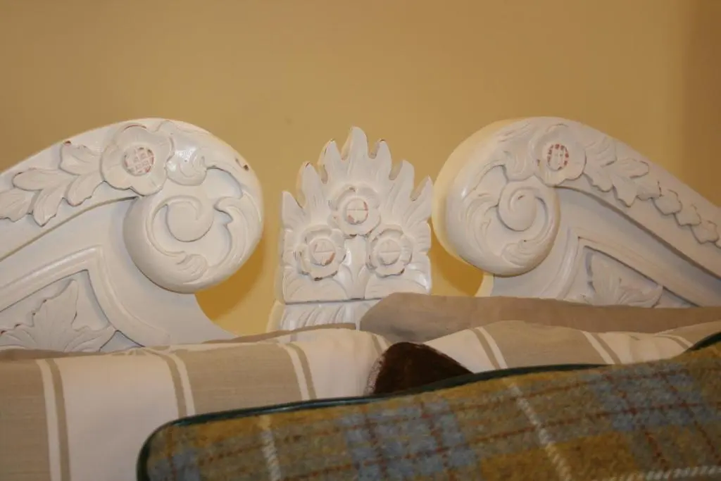 a white bed with a blanket and two white chairs at Ardmeanach in Inverness