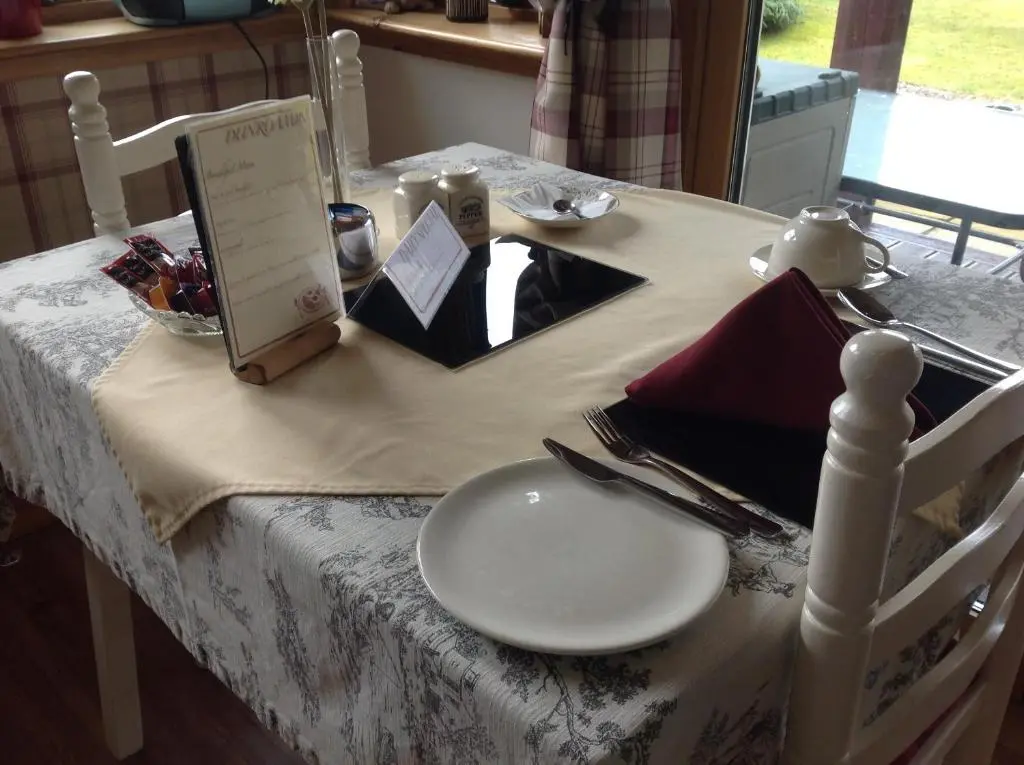 a table with a white plate on top of it at Dunroamin Bed and Breakfast in Aviemore
