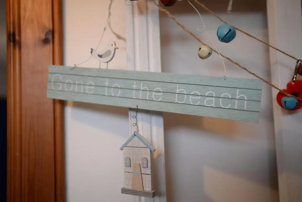 a wooden sign that says come to the beach at Driftwood Cottage, Portsoy in Banff