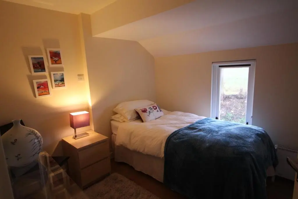 a small bedroom with a bed and a window at Easter Arr Courtyard Apartment in Nairn