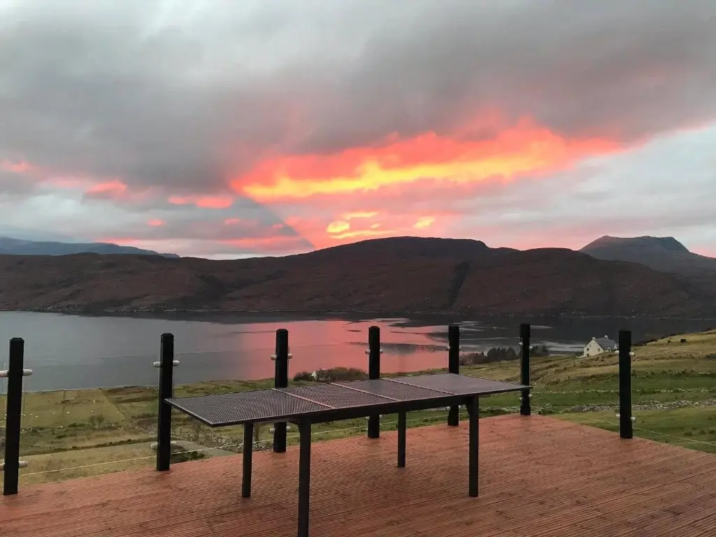 a picnic table with a view of a lake at sunset at Croft No.8 Bed & Breakfast in Ullapool