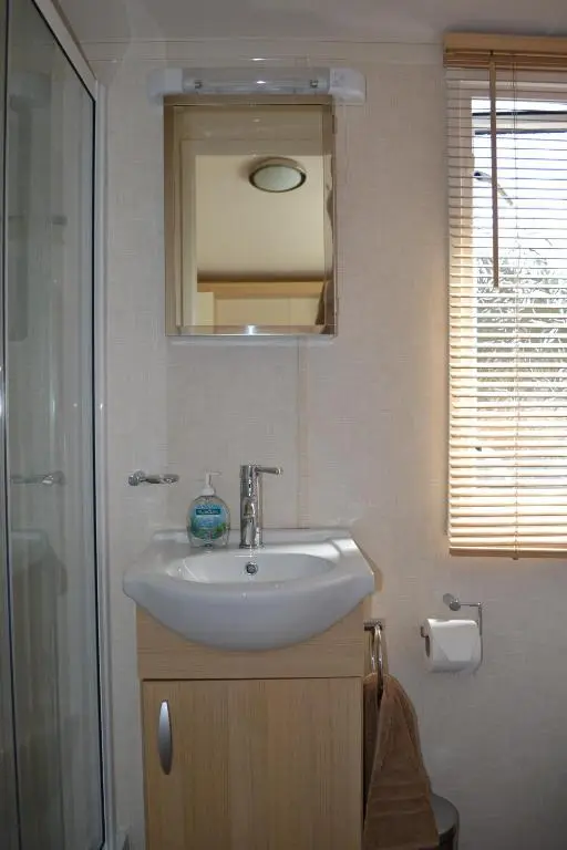 a bathroom with a sink and a shower and a mirror at Braemar in Dornoch